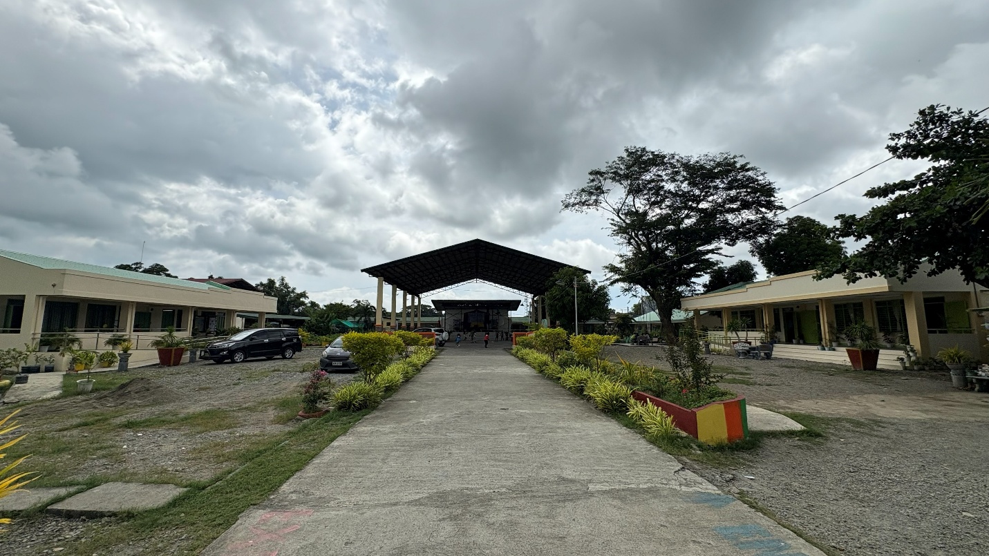 School campus with classroom buildings, a central walkway and covered court